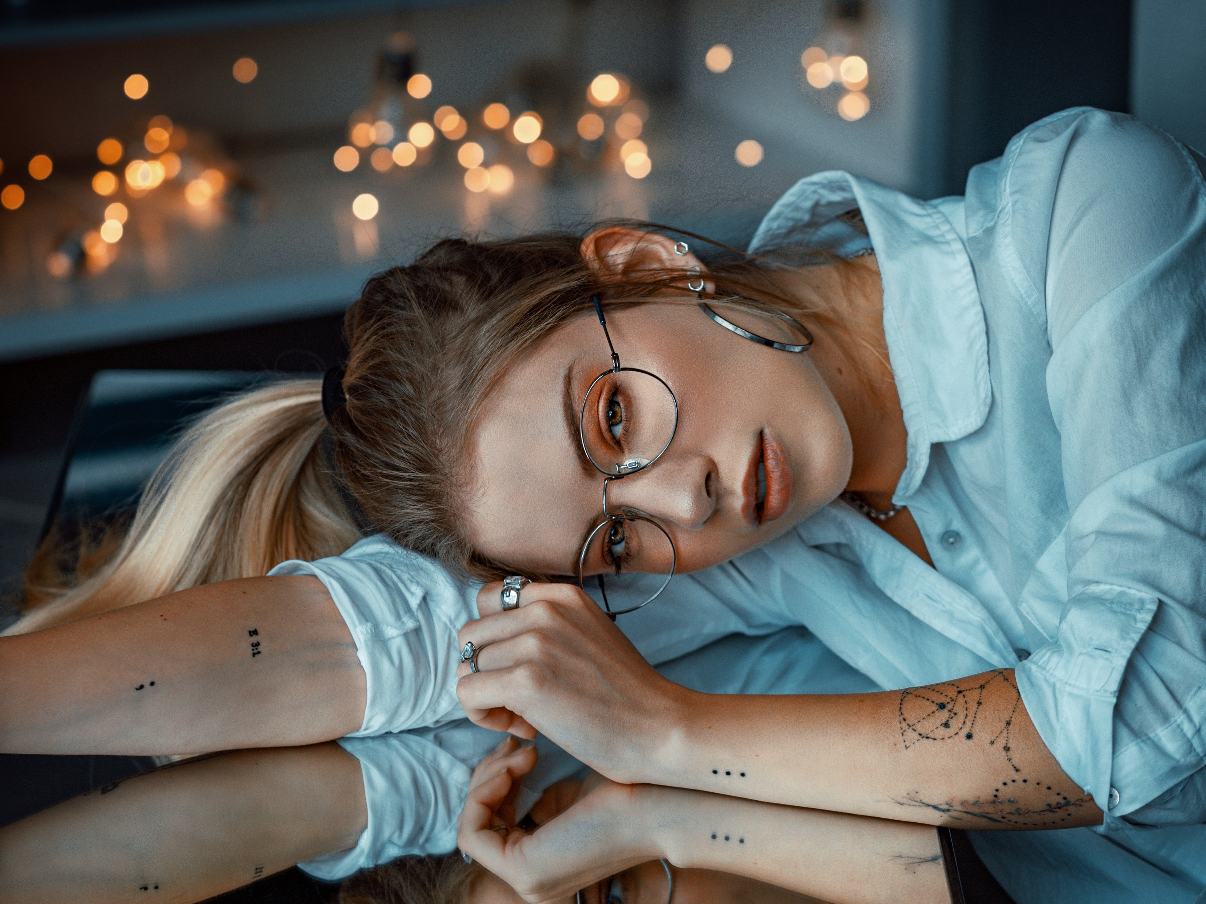Woman wearing glasses with a background of lights